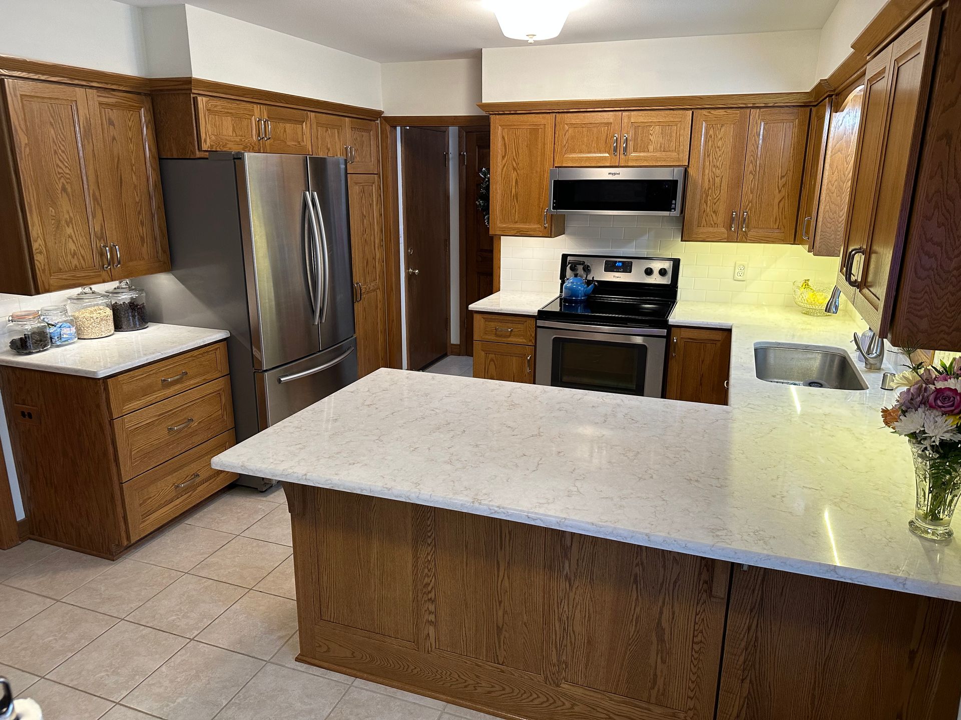 Spacious kitchen with wood cabinets, stainless steel appliances, and a large island counter.