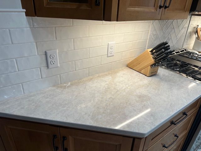 Empty kitchen countertop with white subway tile backsplash and a knife block on the right