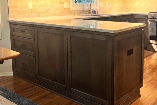 Dark wood kitchen island with granite countertop in a warm-toned kitchen