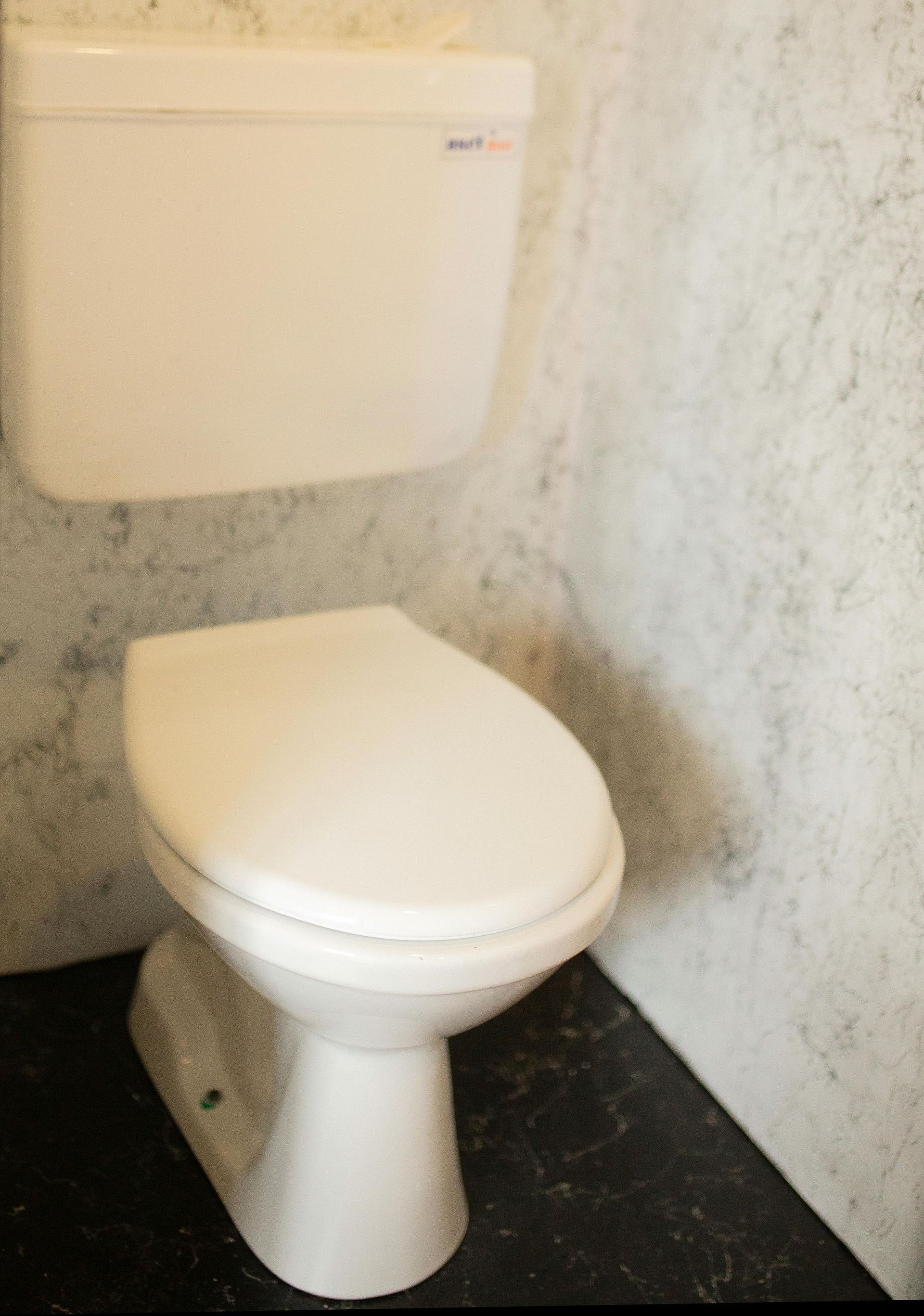 Newly Installed White toilet in a bathroom corner.