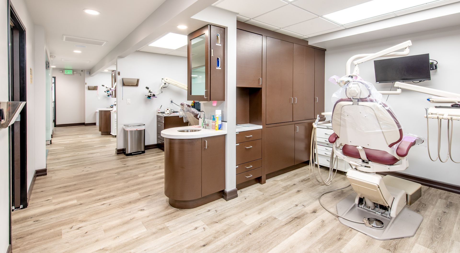 Dental office with a patient chair, cabinets, and equipment.