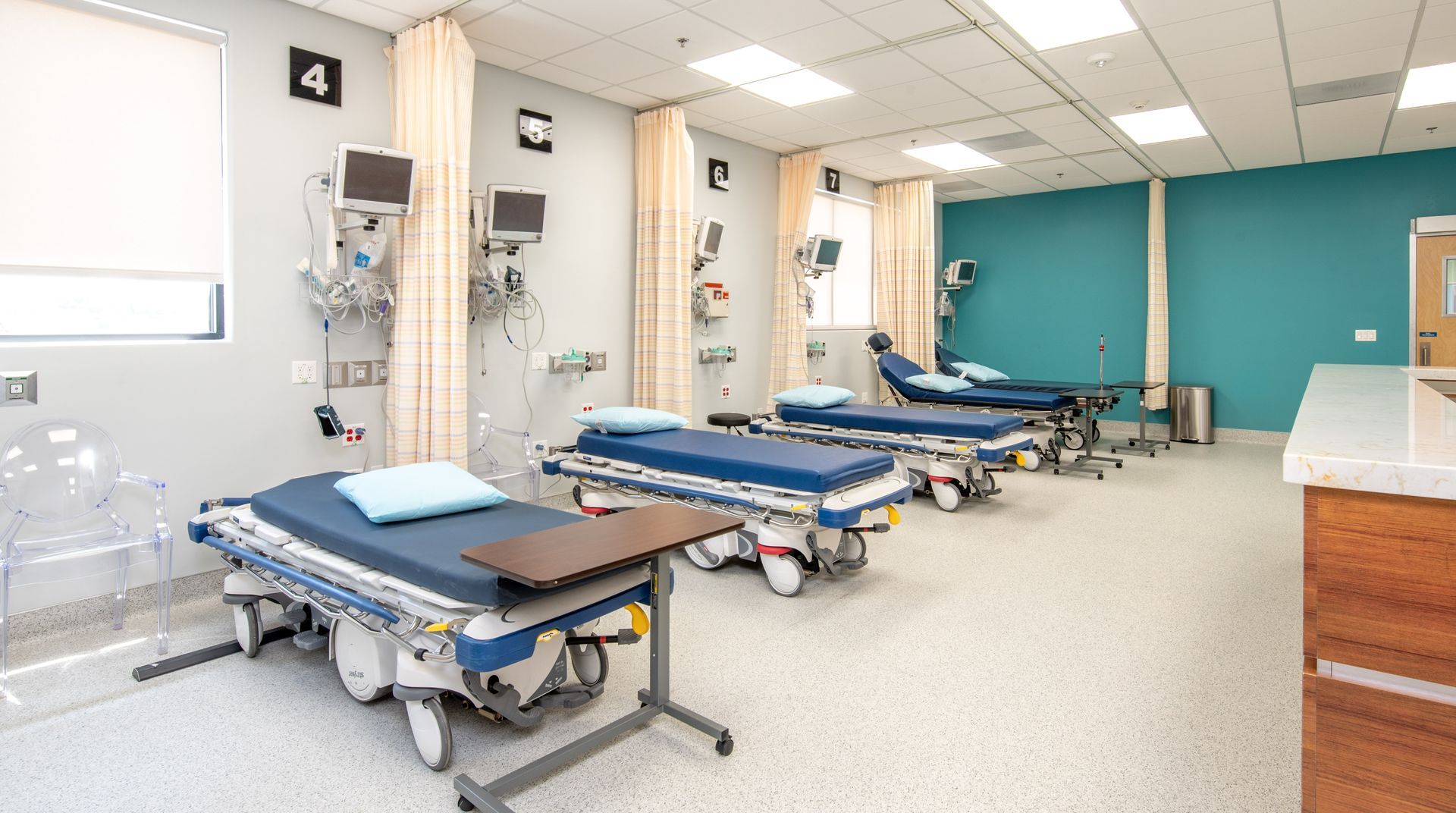 Emergency room with patient beds, medical equipment, and privacy curtains.