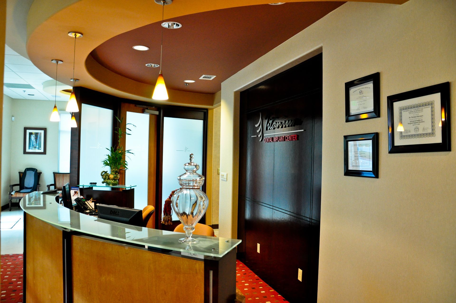 Reception area with a curved desk, framed documents, and an arched ceiling.