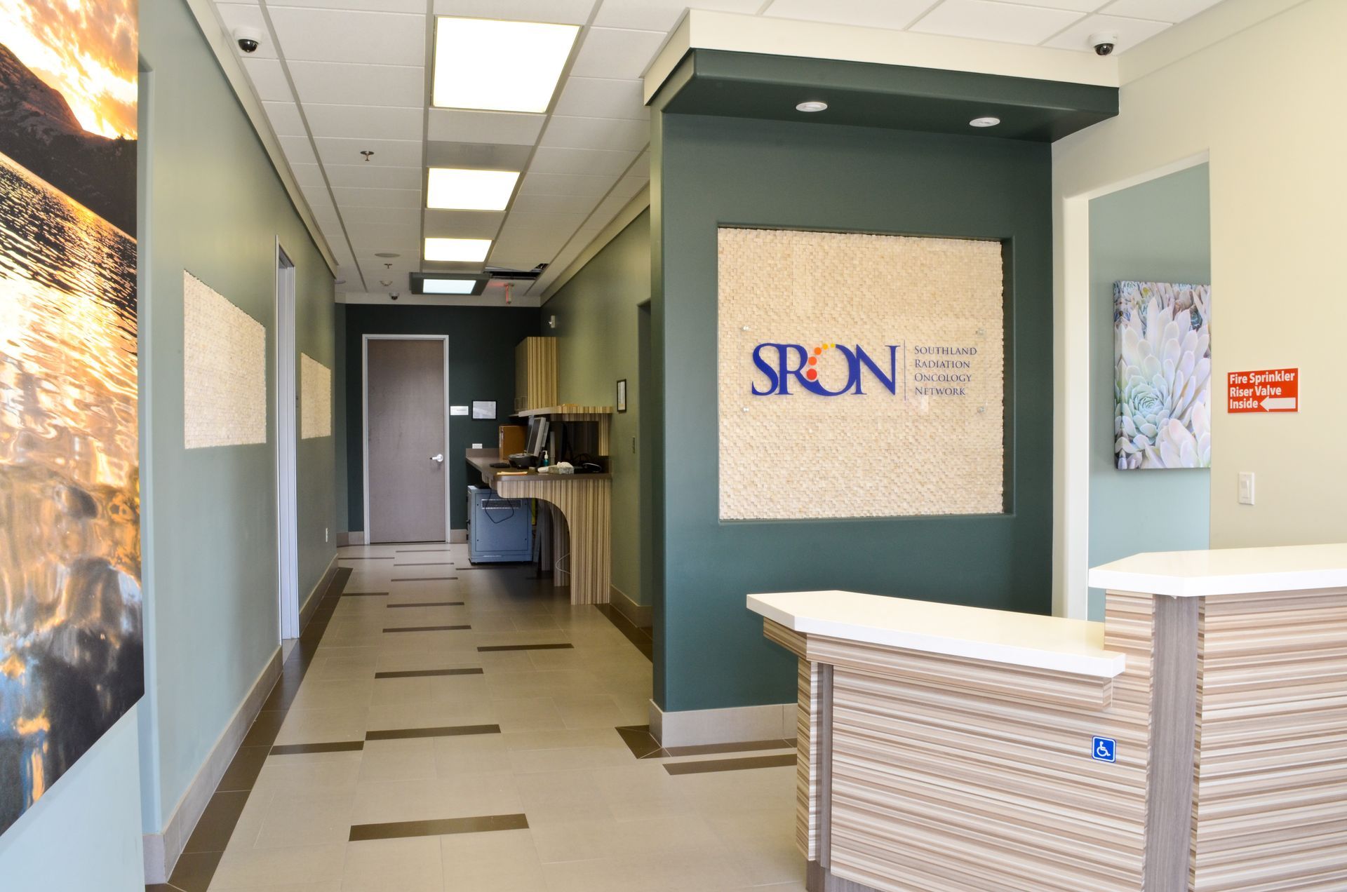 Hallway with reception desk, logo, and doors in a medical office setting.