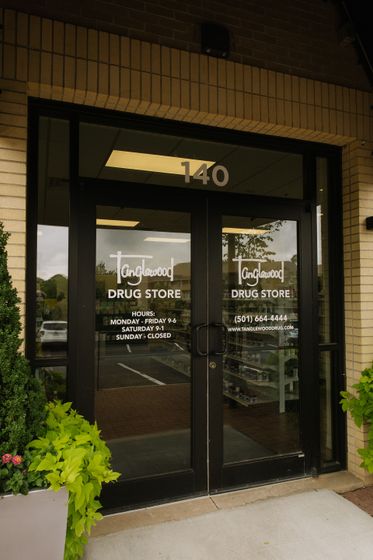 Storefront entrance with black double doors and glass windows, marked “The Medicine Shoppe Drug Store,” at 140.