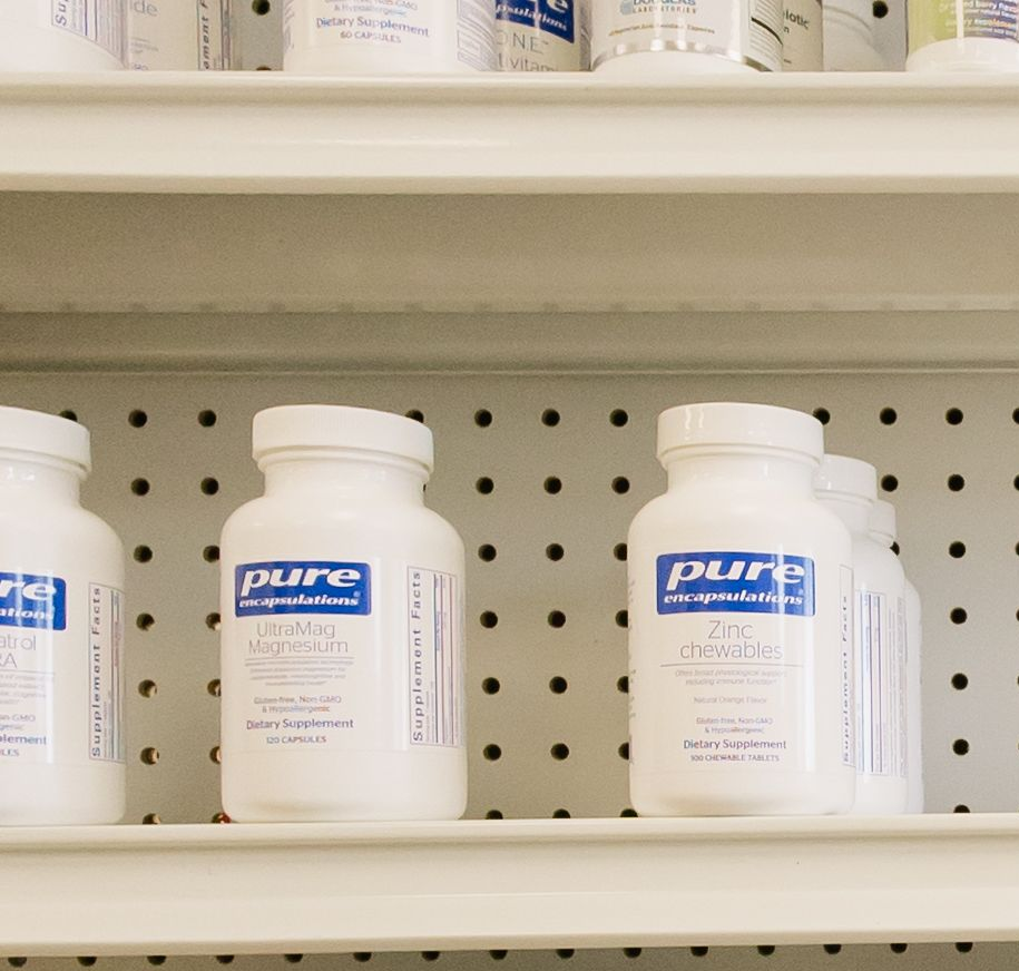 Person holding AG1 and AGZ supplement pouches in a store aisle