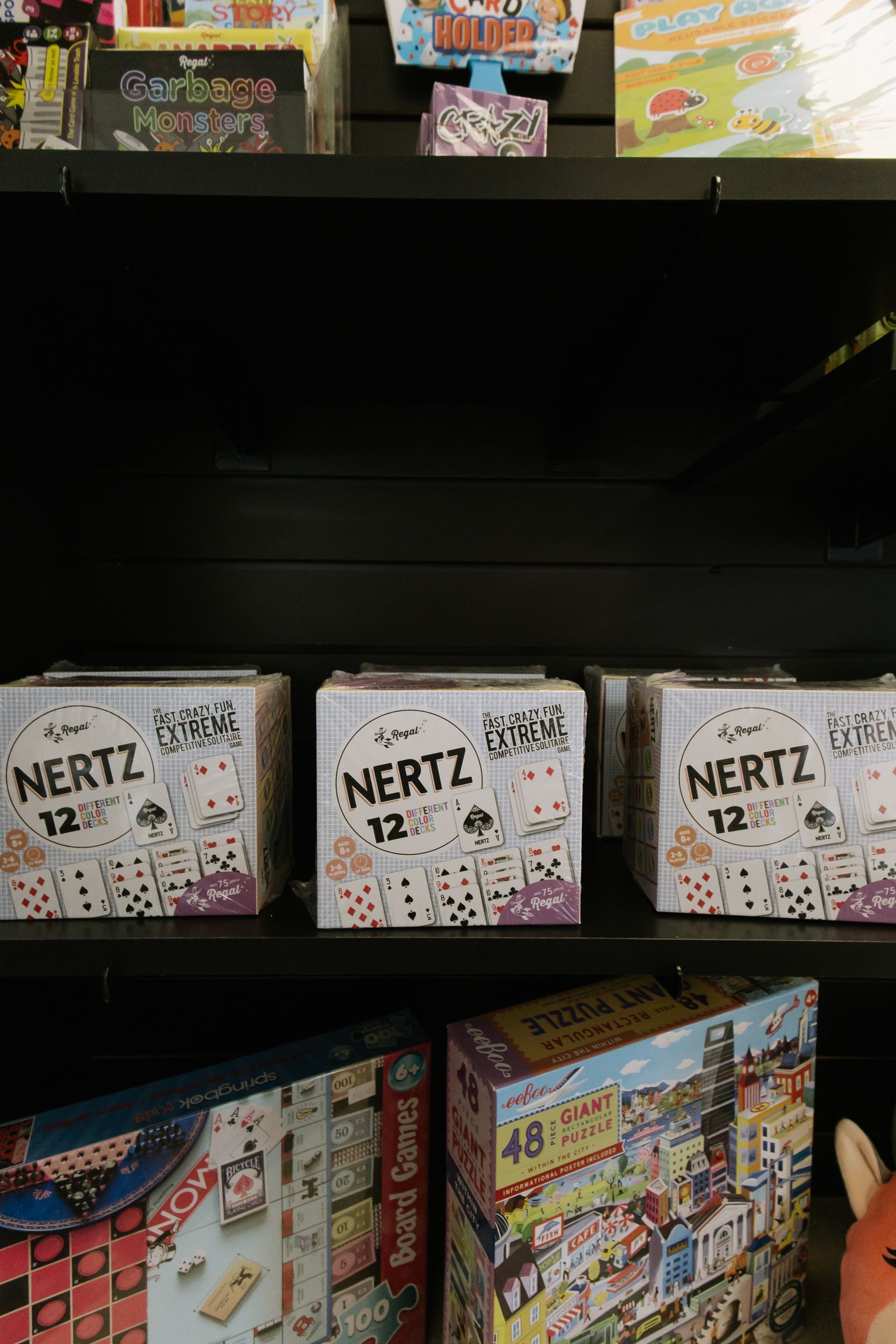 Store shelf with puzzle boxes, including several “NERTZ” games and colorful box sets.