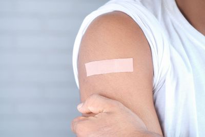 Person with a bandage on upper arm after receiving an injection