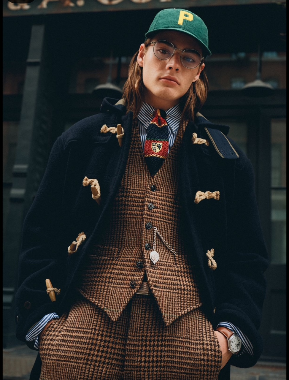 A person in a preppy outfit wearing a green hat with a