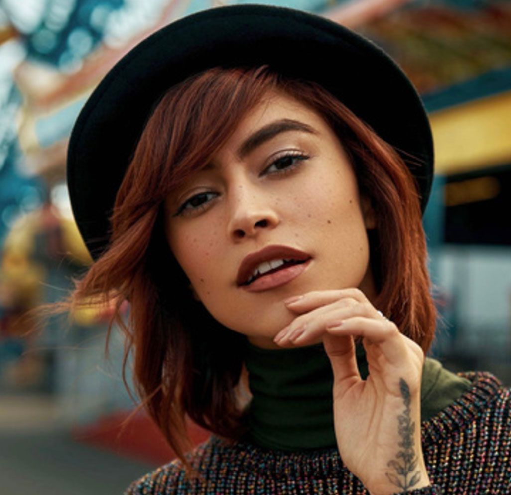 A close up of a woman wearing a hat and a turtleneck