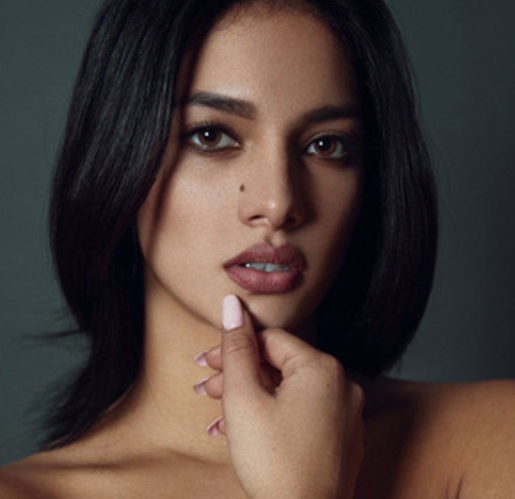 A close up of a woman 's face with her hand on her chin