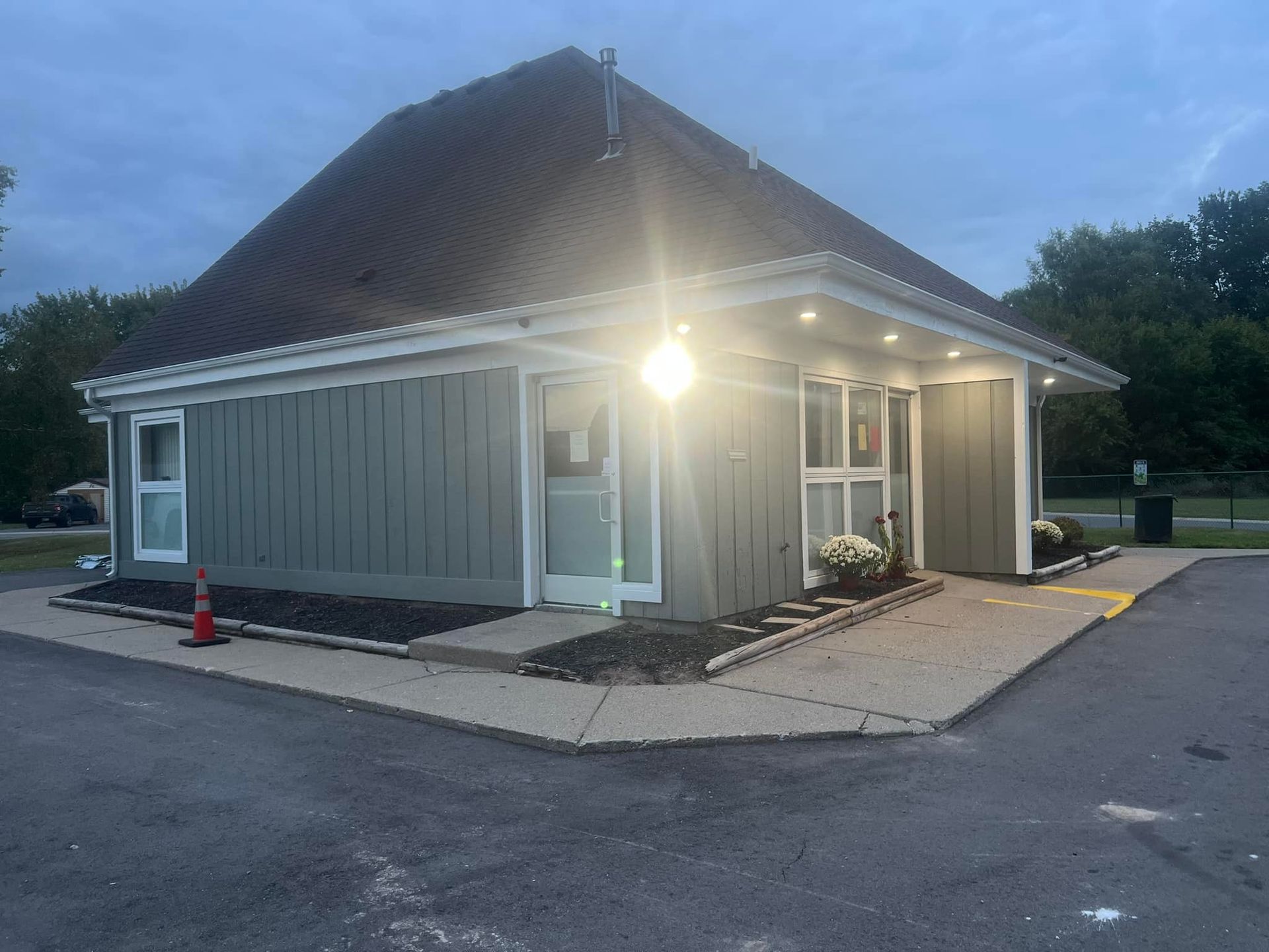 A small building with a lot of windows is lit up at night.