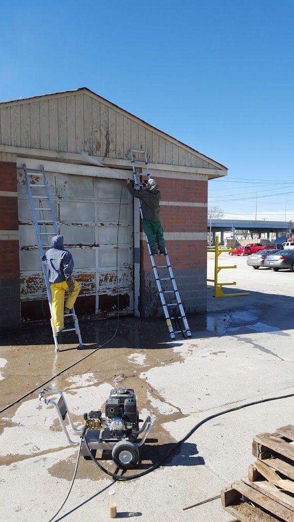 A man on a ladder is cleaning a garage door.