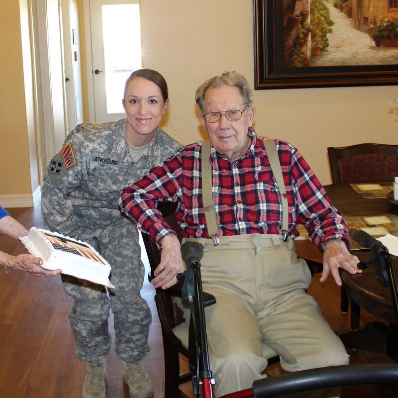 A nurse is holding the hand of an elderly man.