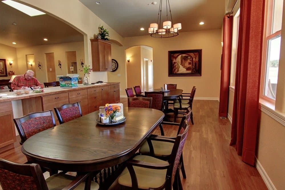 A large dining room with a table and chairs and a chandelier.