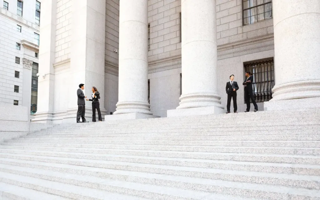 A group of people are standing on the steps of a building.