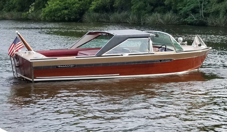 a boat with an american flag on the side is floating on a lake