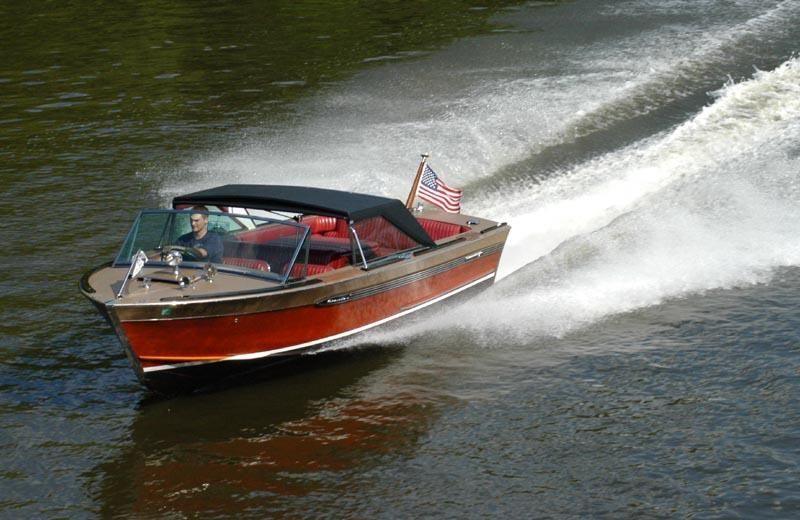 a man is driving a boat on a river .