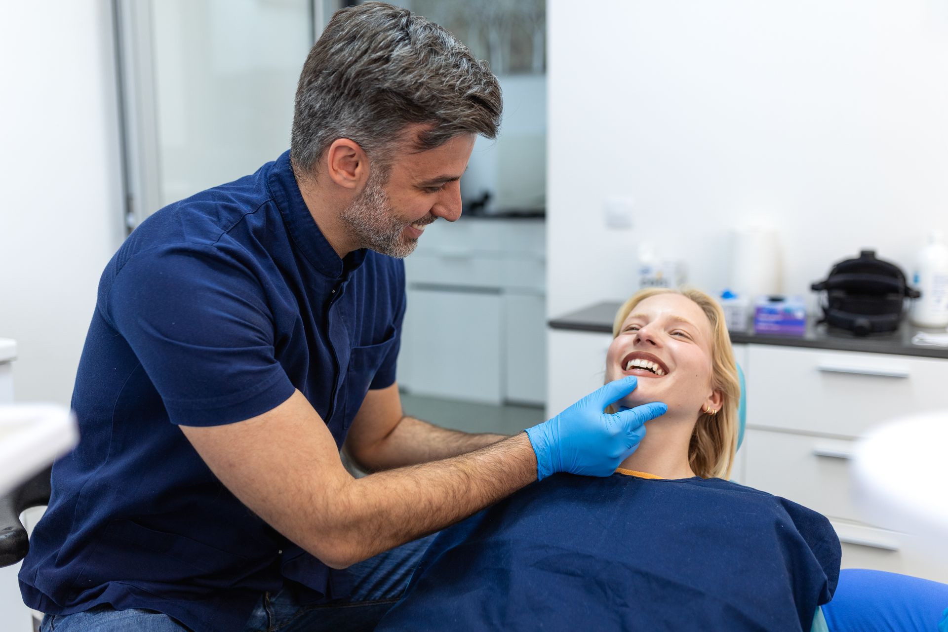 General dentist examining a patient's teeth during a dental visit.