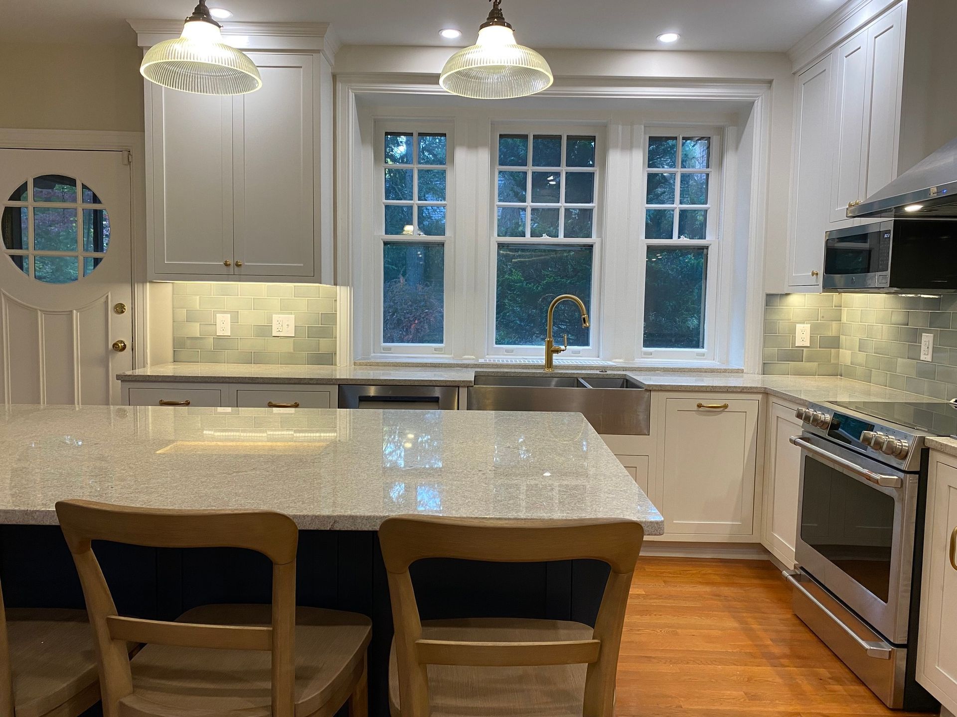 A kitchen with white cabinets , granite counter tops , stainless steel appliances and a large island. James McCoy Remodeling Services Serving 19072,19003,19118,19444,19095 and surrounding areas