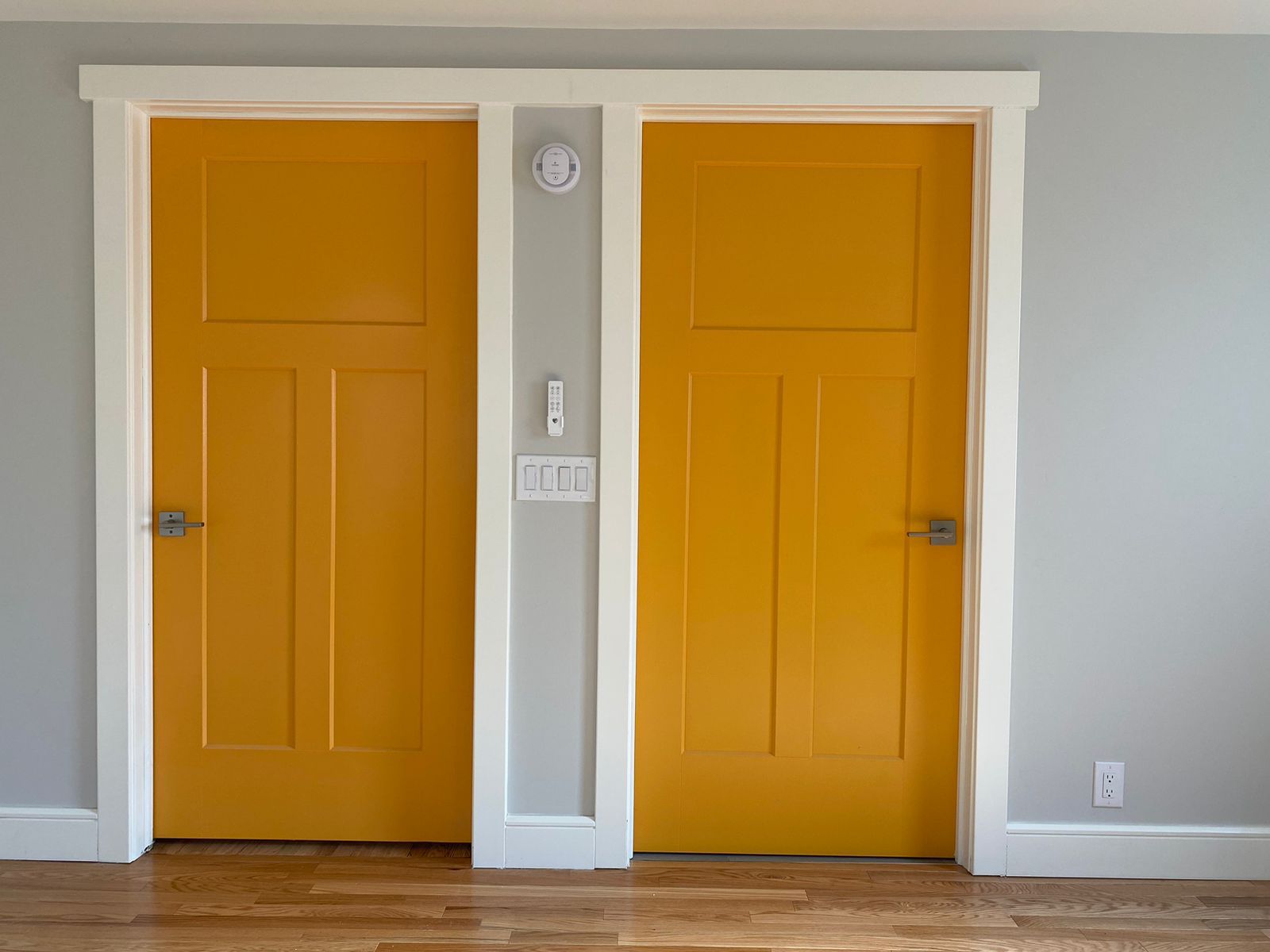 Two yellow doors are sitting next to each other in a room.