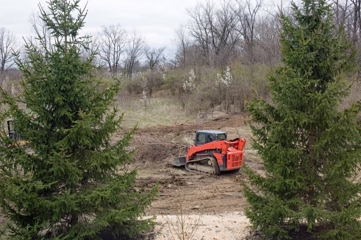 A team using small machines to clear debris from a site near Versailles, KY