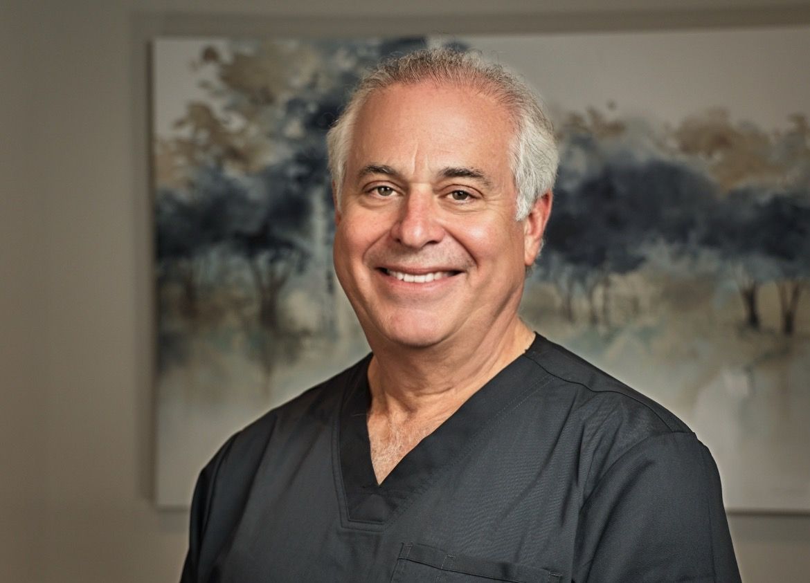 Dr. Marks in a light blue shirt against a blurred indoor background