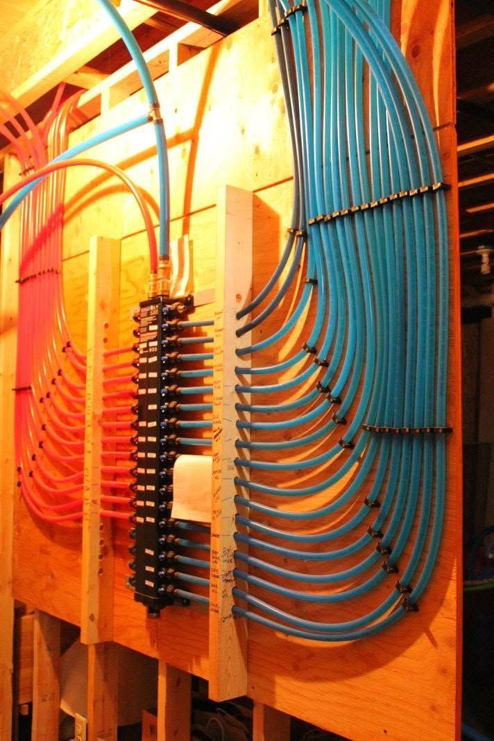 Blue and orange cable bundles routed through a wooden electrical panel rack
