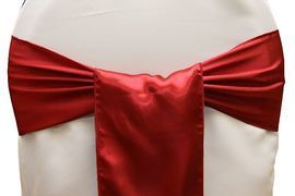 Red satin bow tied around a white chair back