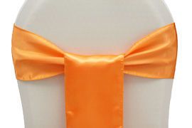 Orange satin chair sash bow on white chair back, centered vertical ribbon detail