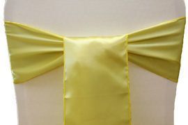 Yellow satin bow tied around a white chair back