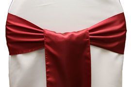 Red satin chair sash tied in a bow over a white chair cover