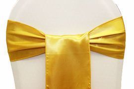 Gold satin bow tied around the back of a white chair