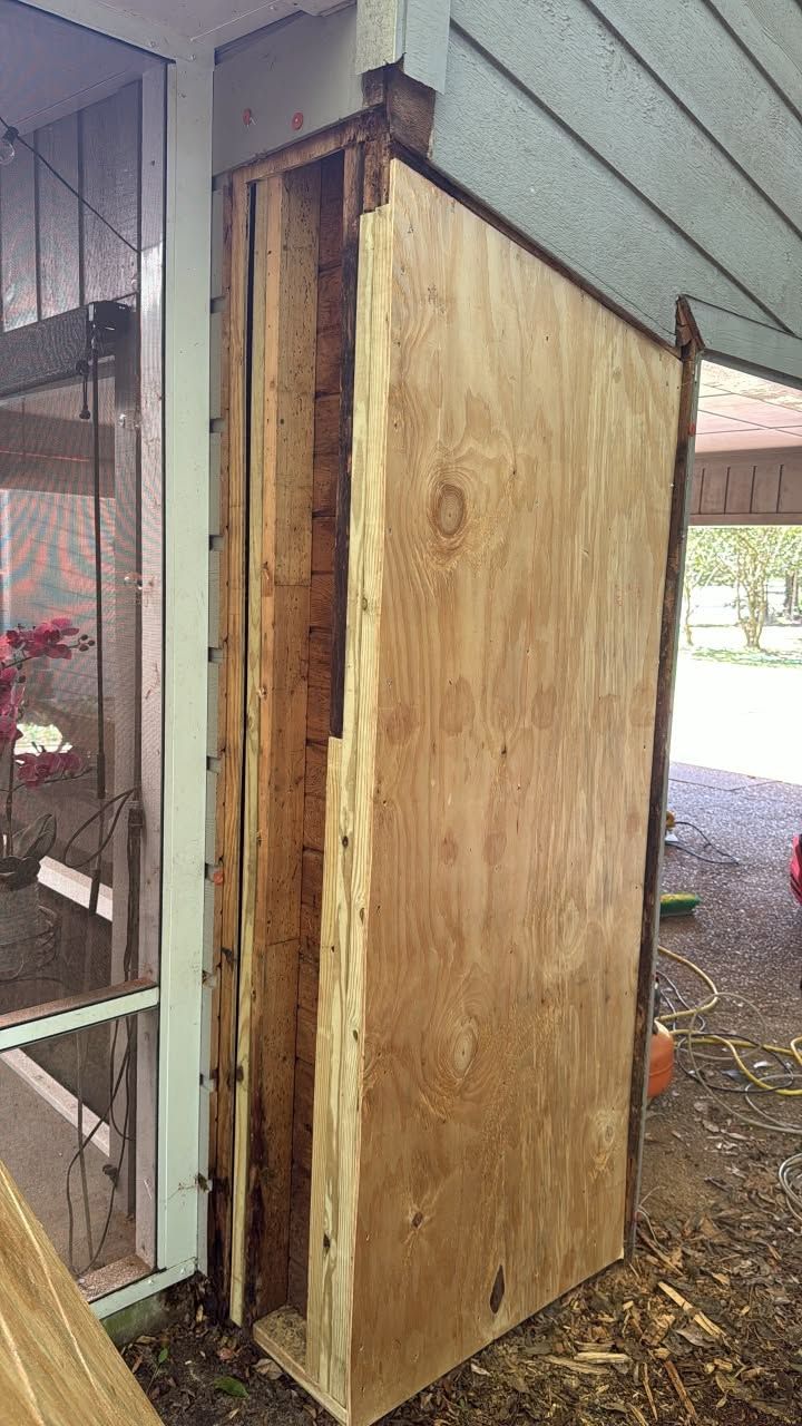 Tall wooden outdoor storage cabinet attached to a house beside a screened porch.