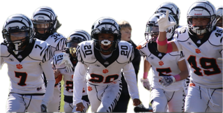 Football players in white uniforms run onto the field during a game.