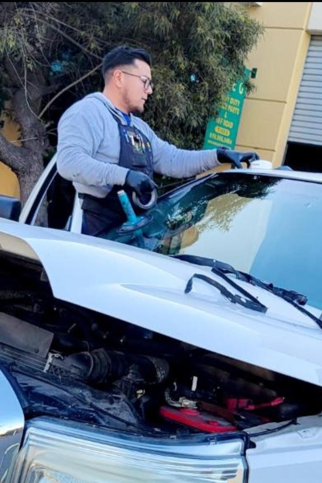 A man is fixing a windshield on a truck.
