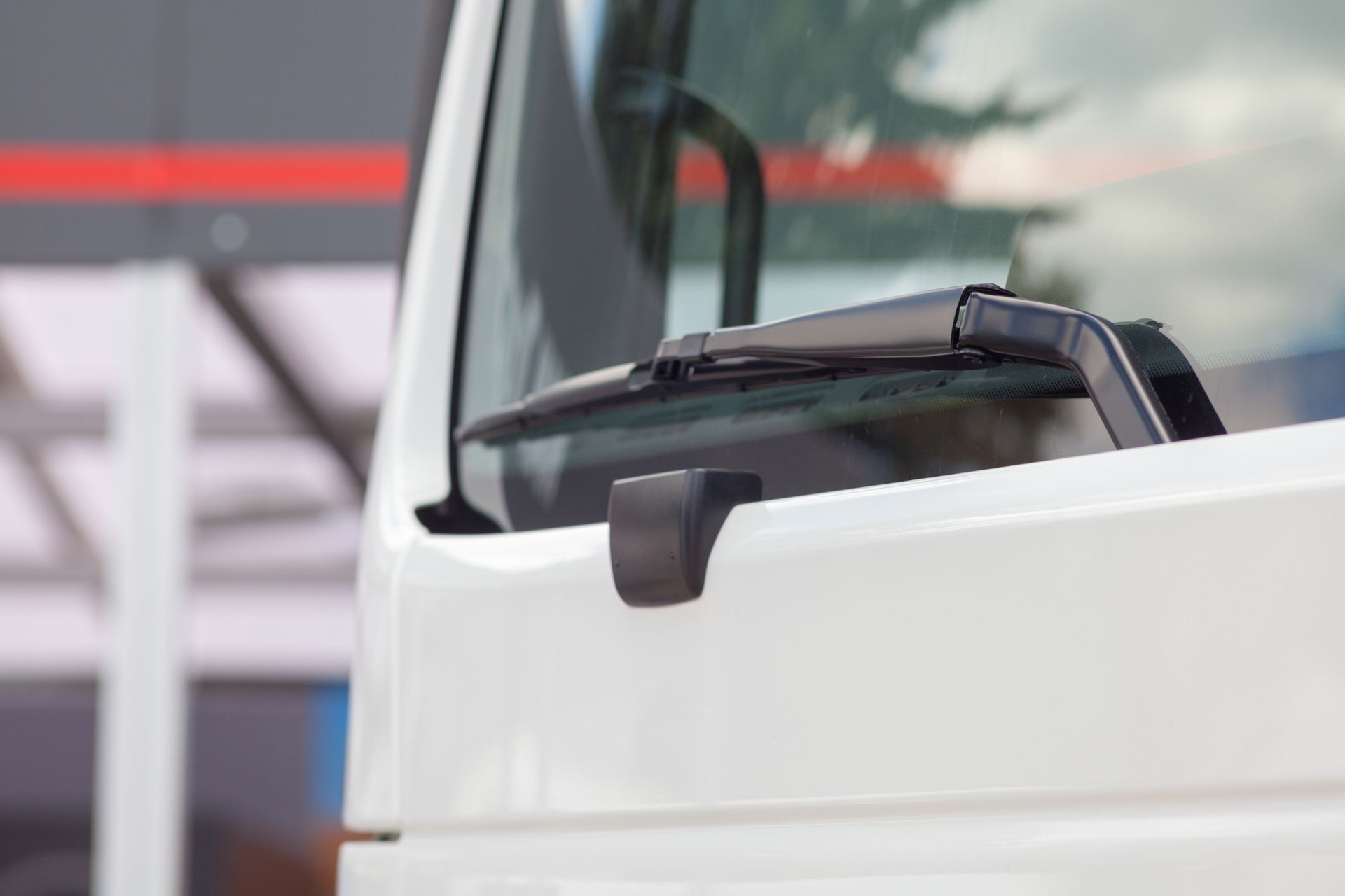 A White Truck with A Wiper on The Windshield Is Parked in Front of A Building. A White Truck with A Wiper on The Windshield Is Parked in Front of A Building.