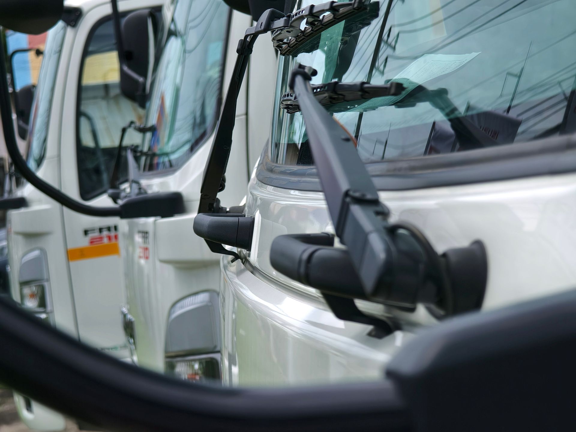 A Row of White Trucks Are Parked Next to Each Other. A Row of White Trucks Are Parked Next to Each Other.