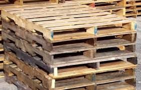 Stacked wooden shipping pallets in a warehouse-like setting