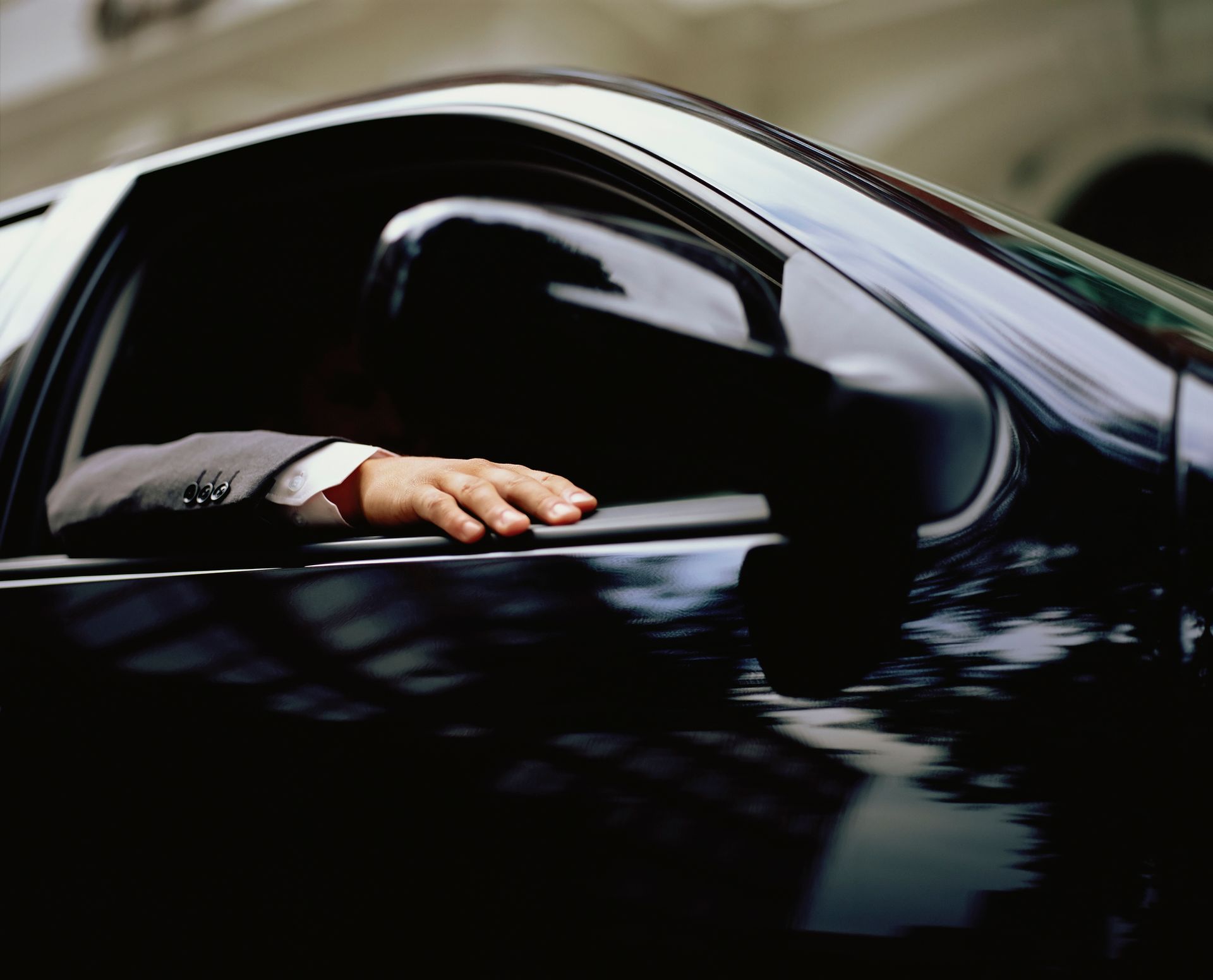 A man in a suit is sitting in a black car