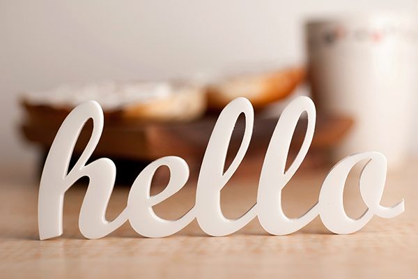a white sign that says hello on a table