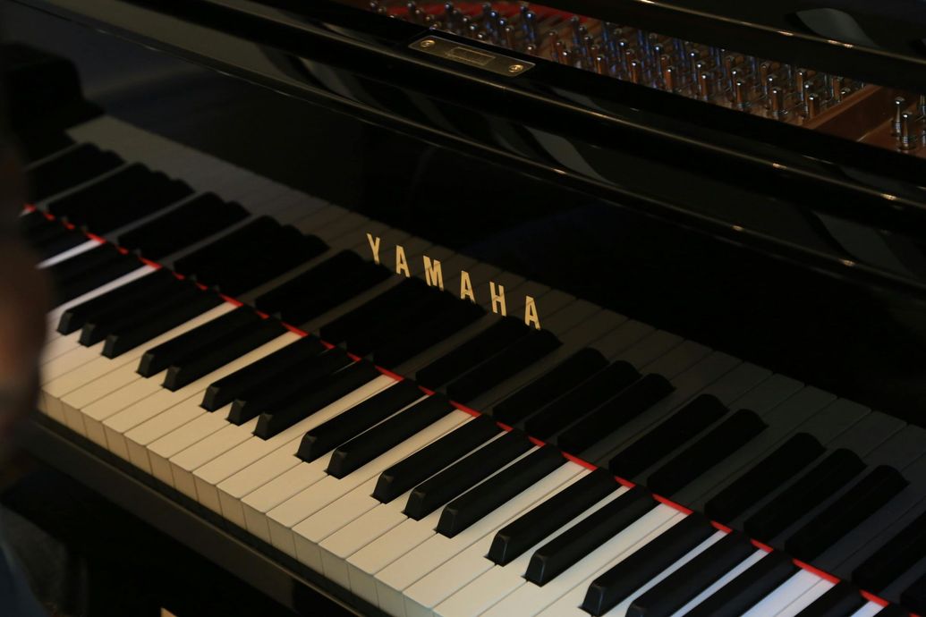 Close-up of a black Yamaha piano keyboard with glossy finish and gold logo