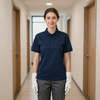 Person in navy polo shirt and white gloves standing in a hallway between office doors.