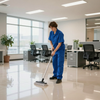 Person mopping a shiny office floor in a bright open workspace