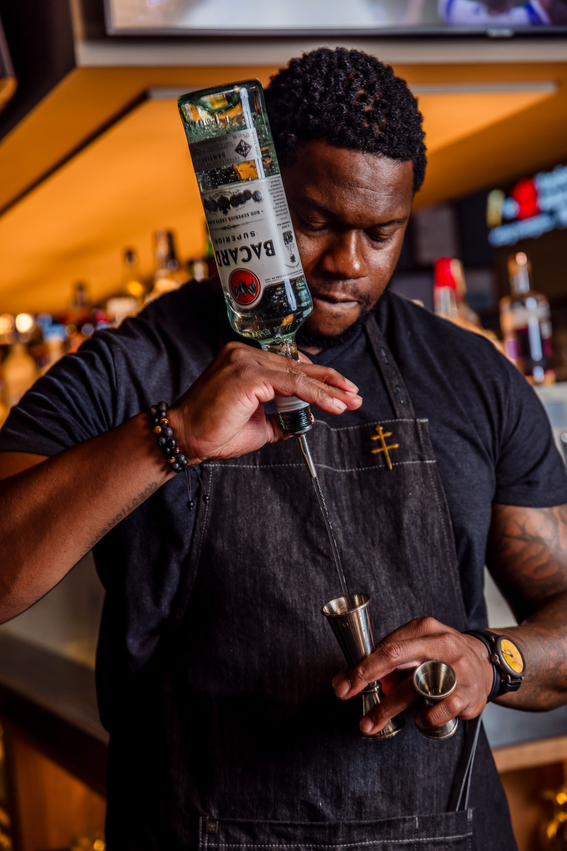 A bartender is pouring a drink from a bottle of bacardi