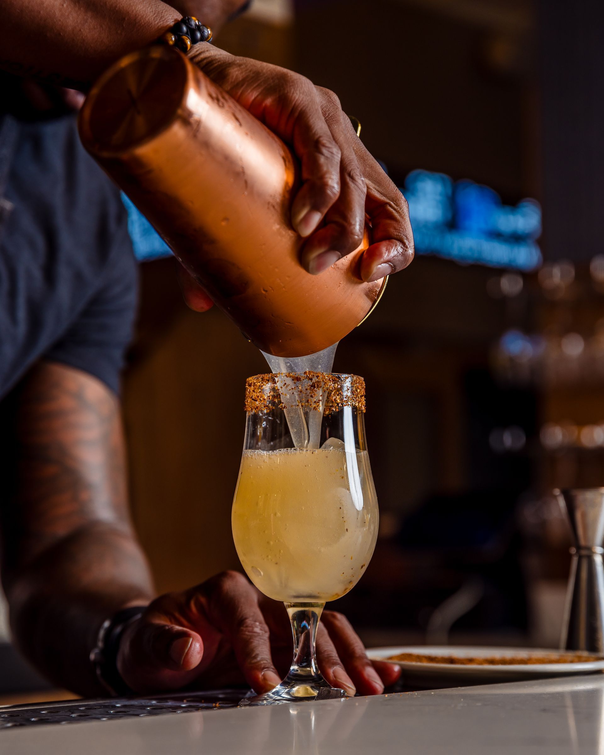 A bartender is pouring a drink into a glass