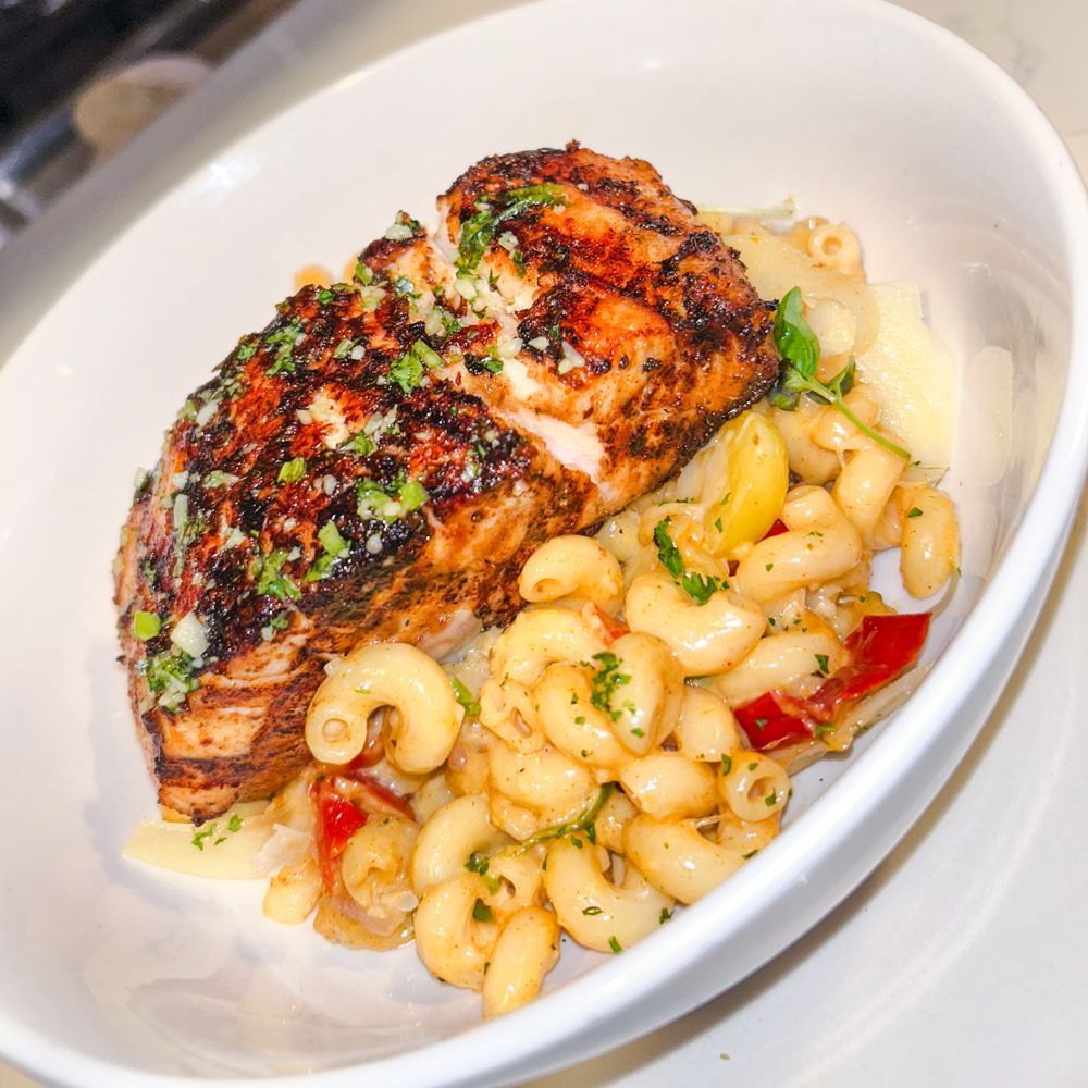 A white bowl filled with macaroni and cheese and chicken