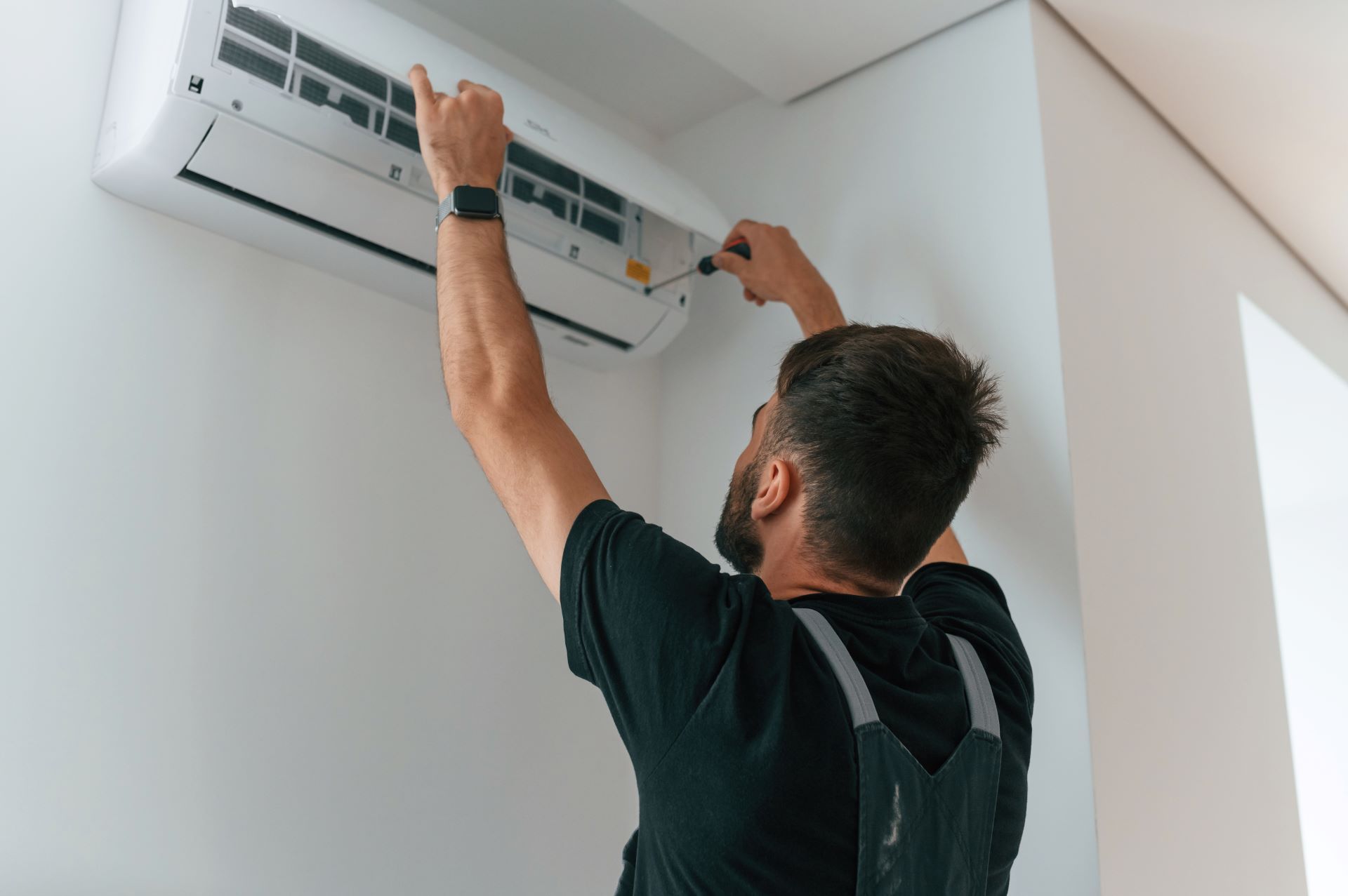 man fixing musty smell in air conditioner