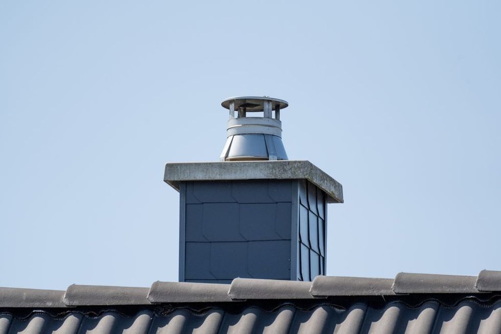 Roof vent chimney against a clear blue sky