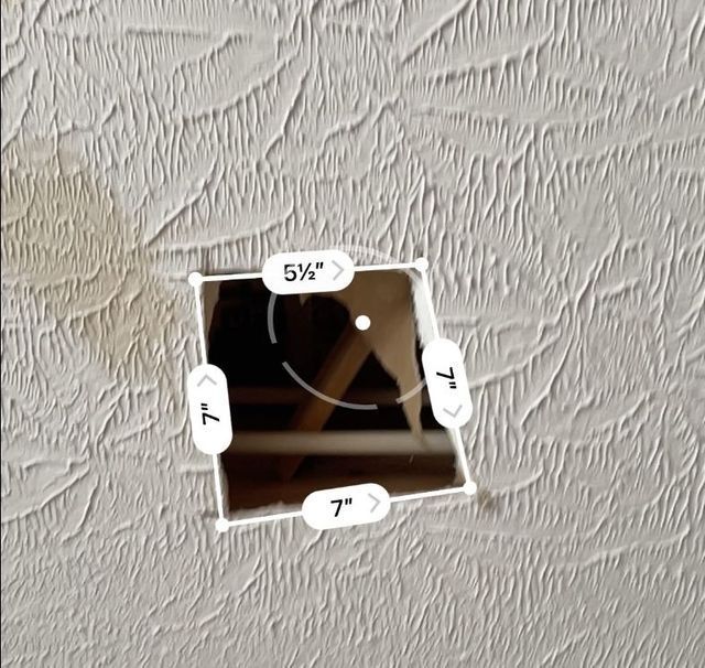 a picture of a smiley face is being measured on a wall